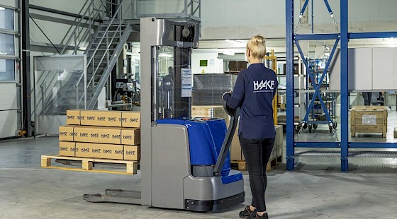 Haake Mitarbeiterin mit elektrischem Hubwagen
